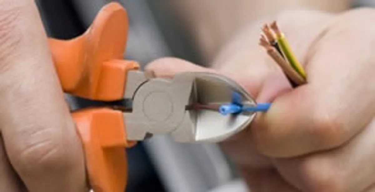 licensed electrician performing precise wire cutting and preparation during electrical service in Cleveland, OH
